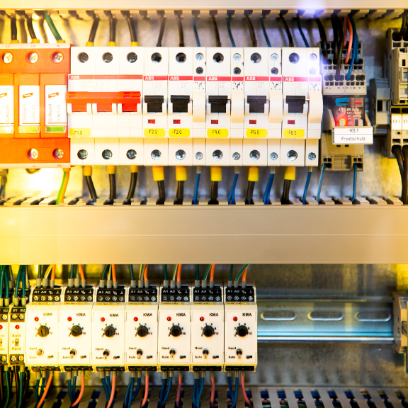 Ein bunter Schaltschrank mit zahlreichen Sicherungen und Kabeln in klarer Anordnung