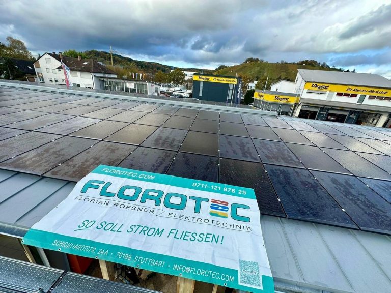 Eine Solaranlage auf einem Dach mit bewölktem Himmel und umliegenden Gebäuden