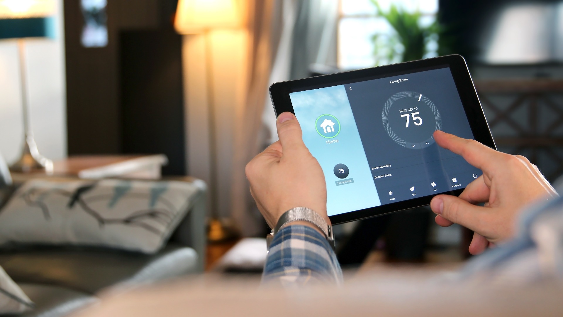 Mann stellt die Temperatur mit einem Tablet mit Smart Home ein