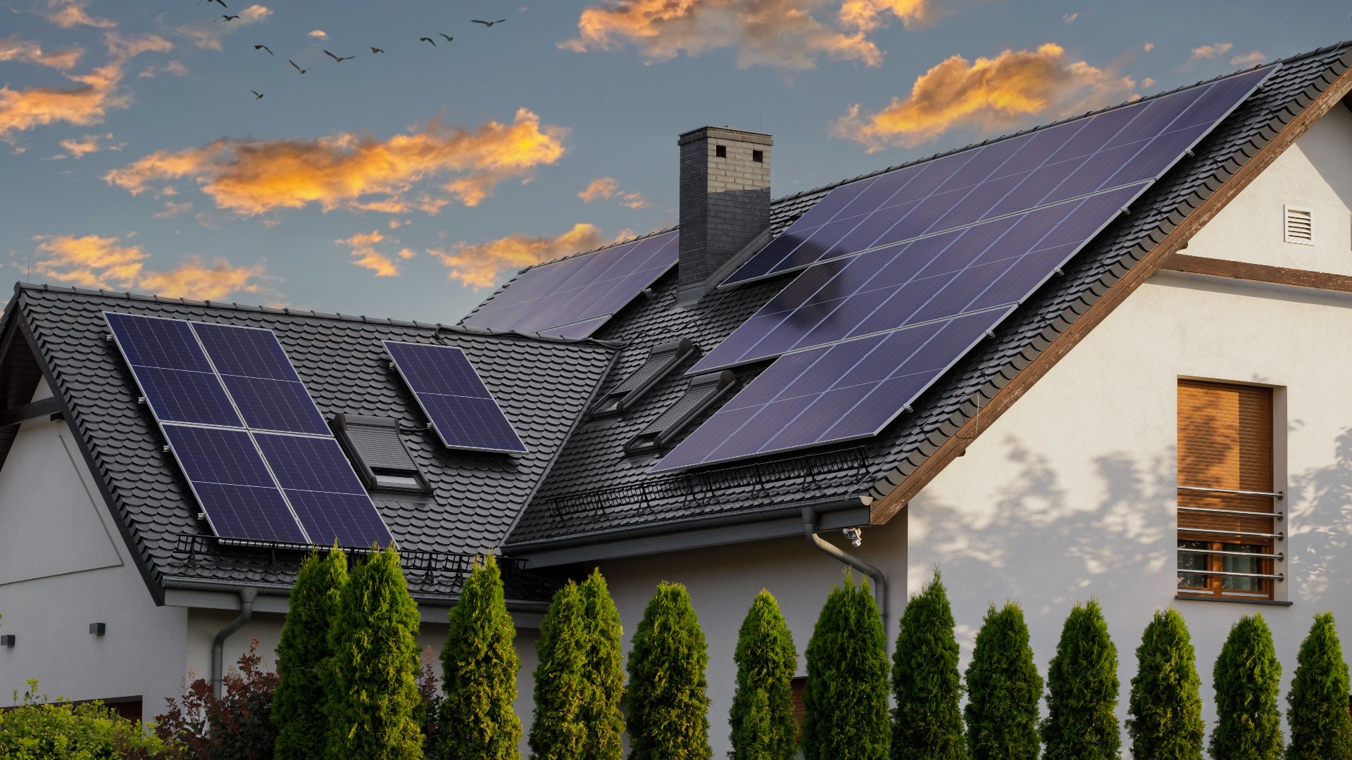 Modernes Haus mit blauen Sonnenkollektoren auf dem Dach. Ende des Tages, Sonnenuntergang. Idyllische Atmosphäre.