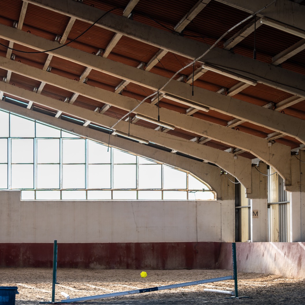 Innenansicht einer Reithalle mit Springhindernis